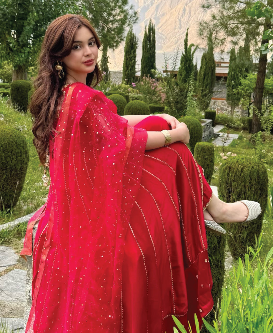 Flowing silhouette of crimson red women’s formal anghra anarkali frock with traditional drape
