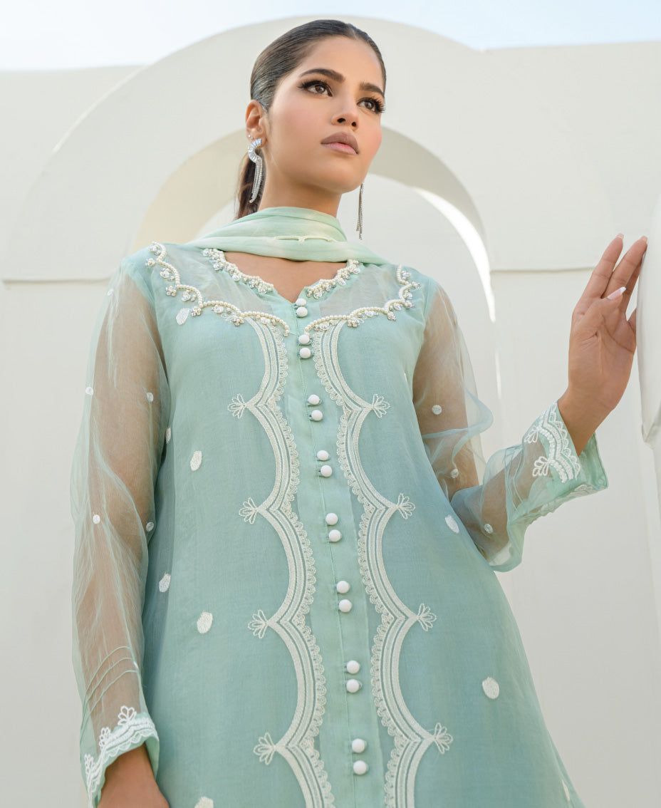 mint green organza outfit with hand embellishment detailing on the front of the shirt.