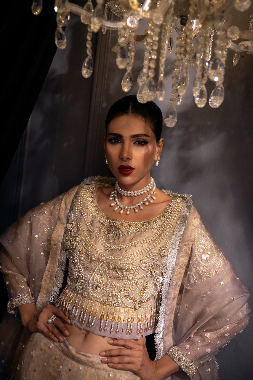 Lilac Lumière showcases a statement designer choli enriched with pearl, crystal and sequin artistry, creating a luminous couture look in soft lilac tones.